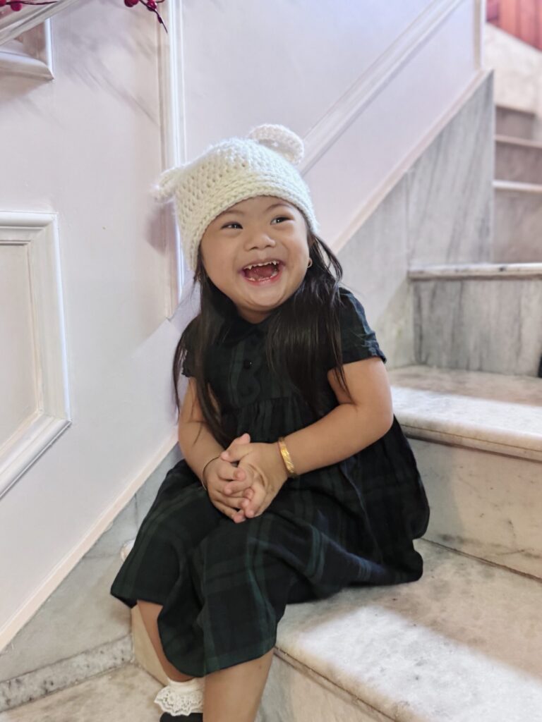 Alashi in a knitted hat, sitting on a staircase