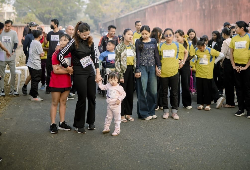 Alashi walking hand in hand with her family at a community walk